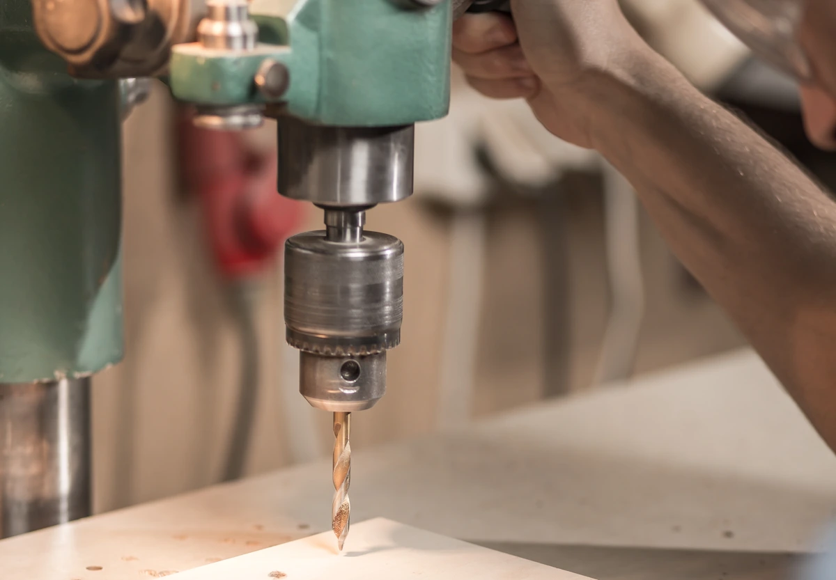 Une personne qui perce de l'inox